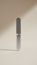 A centered, straight-on view of a travel-friendly nail file, showcasing its refined design and compact form. The file is...